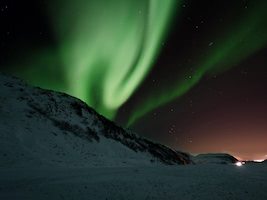 Northern lights above a house at night