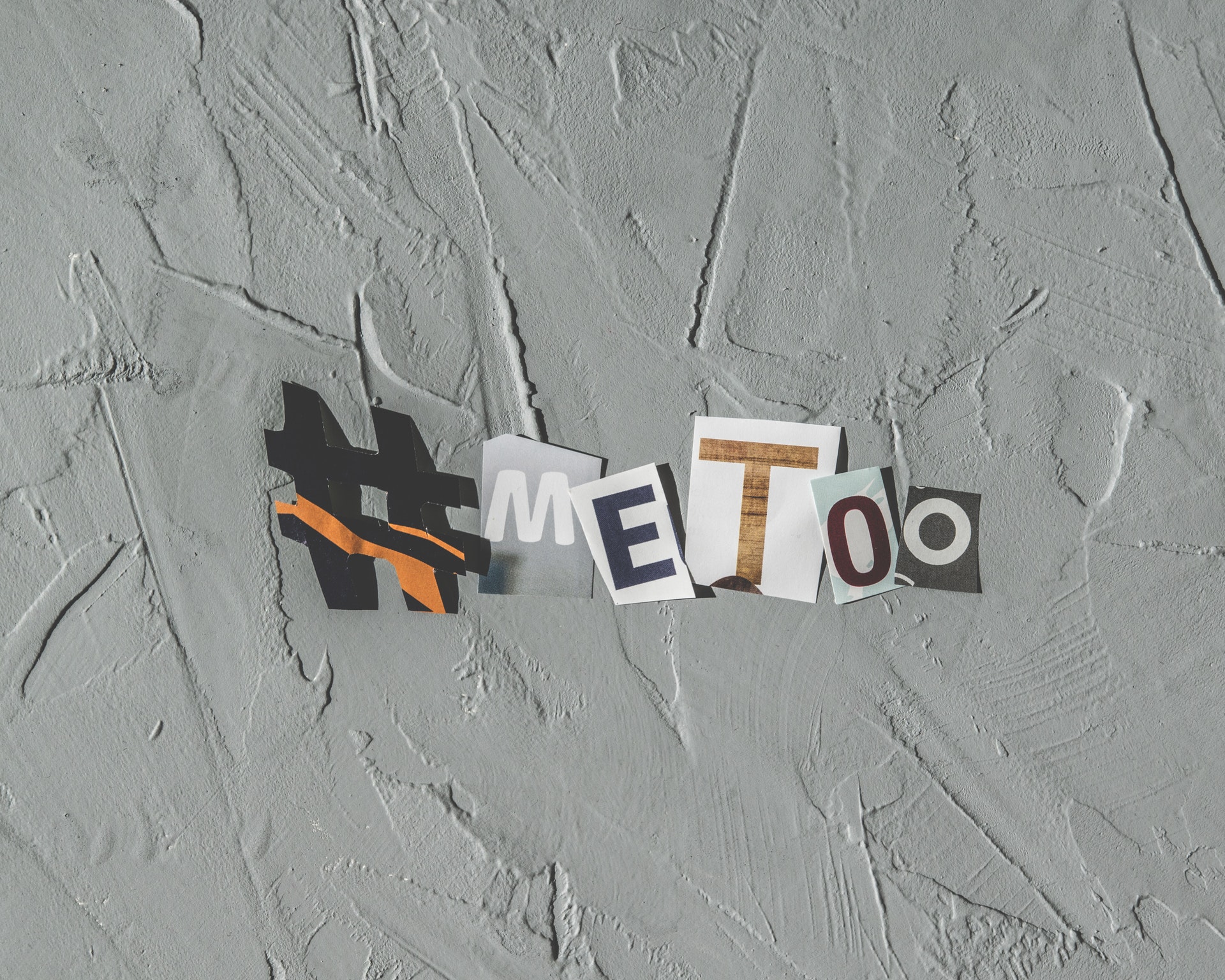 le hashtag MeToo composé par plusieurs morceaux de papier journal sur un fond gris